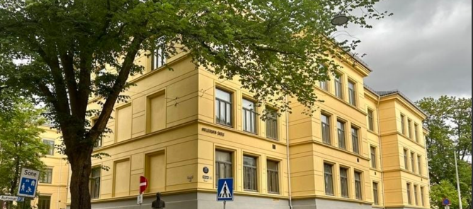 En gul bygning med svart gjerde En gul bygning med svart gjerde