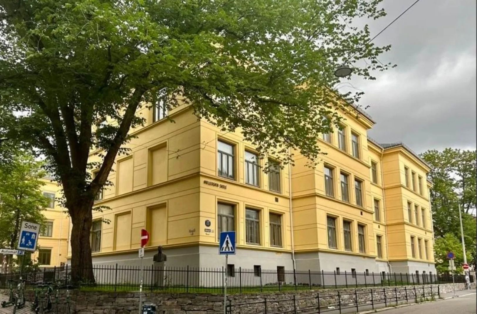En gul bygning med svart gjerde En gul bygning med svart gjerde